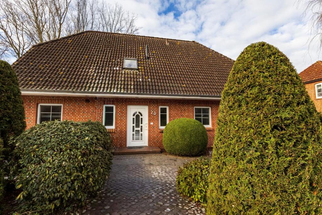a red brick house with trees in front of it at Appartement Dorfluft in Böhl