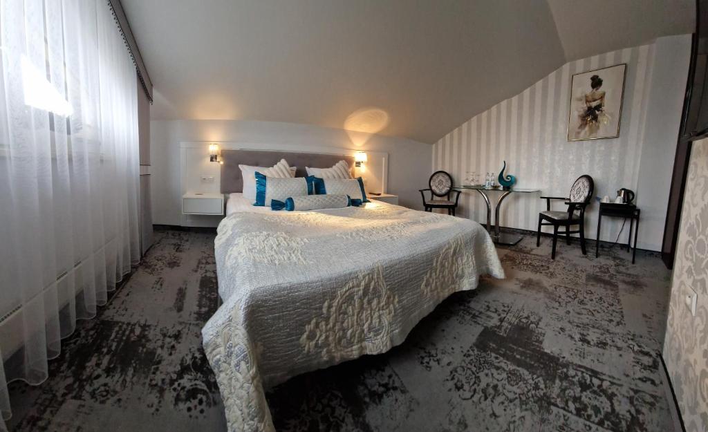 ein Schlafzimmer mit einem großen Bett und blauen Kissen in der Unterkunft Cynamon in Nowy Sącz