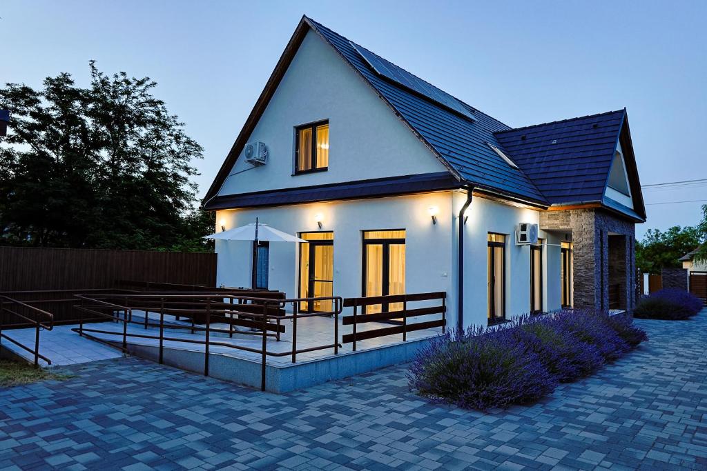 a small white house with benches in front of it at Silver Cottage in Máriapócs