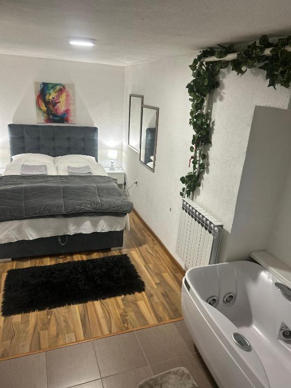 a bedroom with a bed and a bath tub at Apartman MIA in Travnik