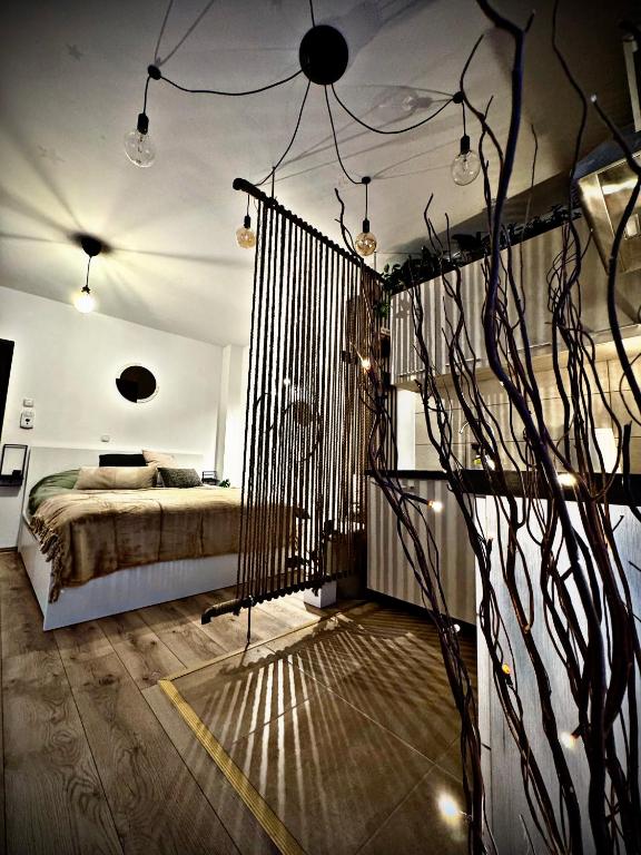 a bedroom with a bed and a tree in it at VerdeViu Apartments 2 Prima Green Residence in Oradea