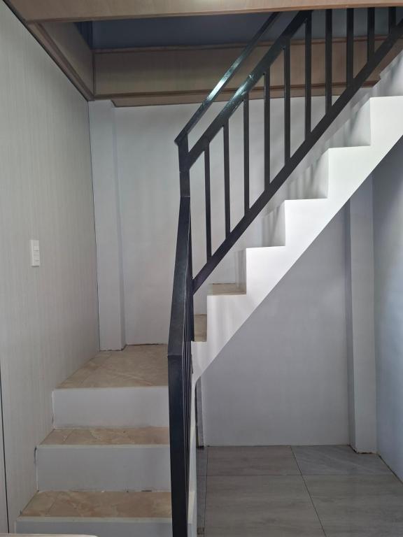 a staircase in a house with white walls at Nancy's Place in Caniton