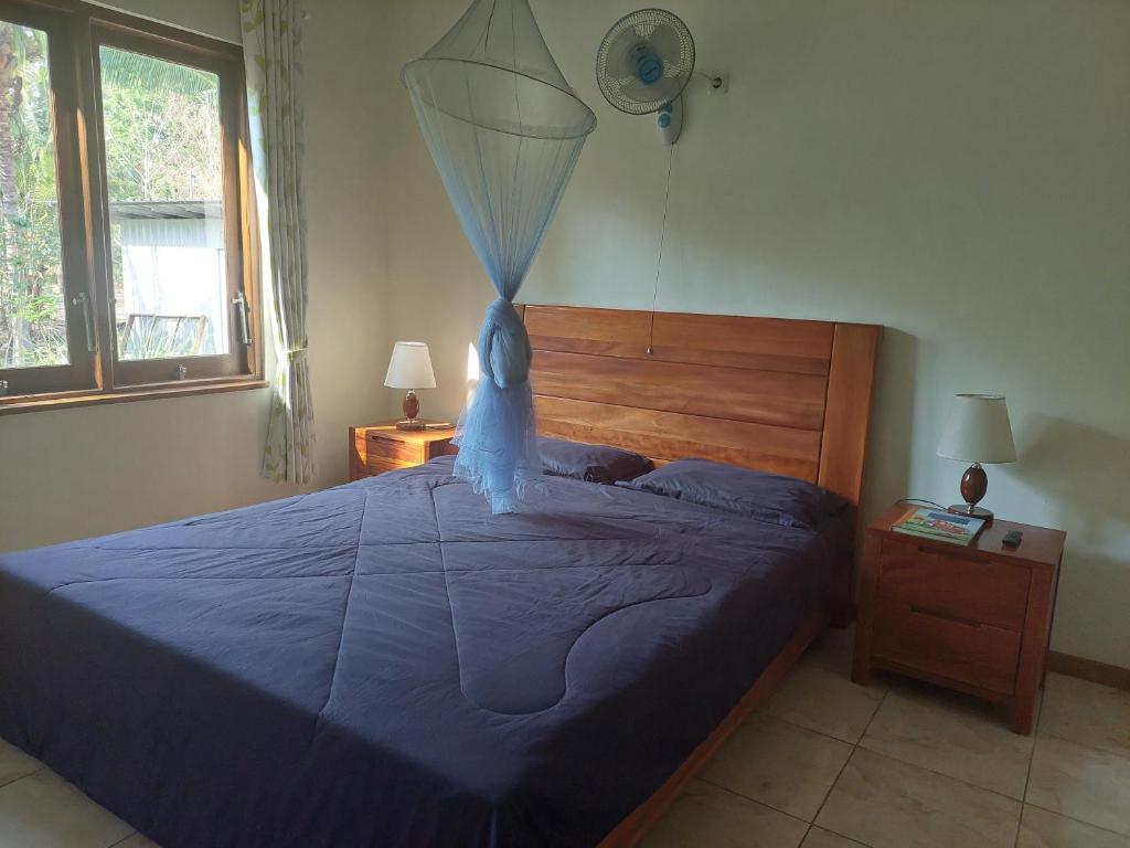 a bedroom with a blue bed with a net on it at Arche Noah in Kalabahi