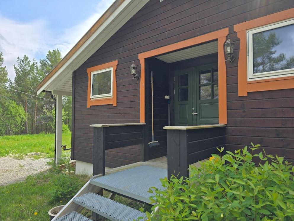 a brown house with a green door and a porch at Fjellro appartment in Os