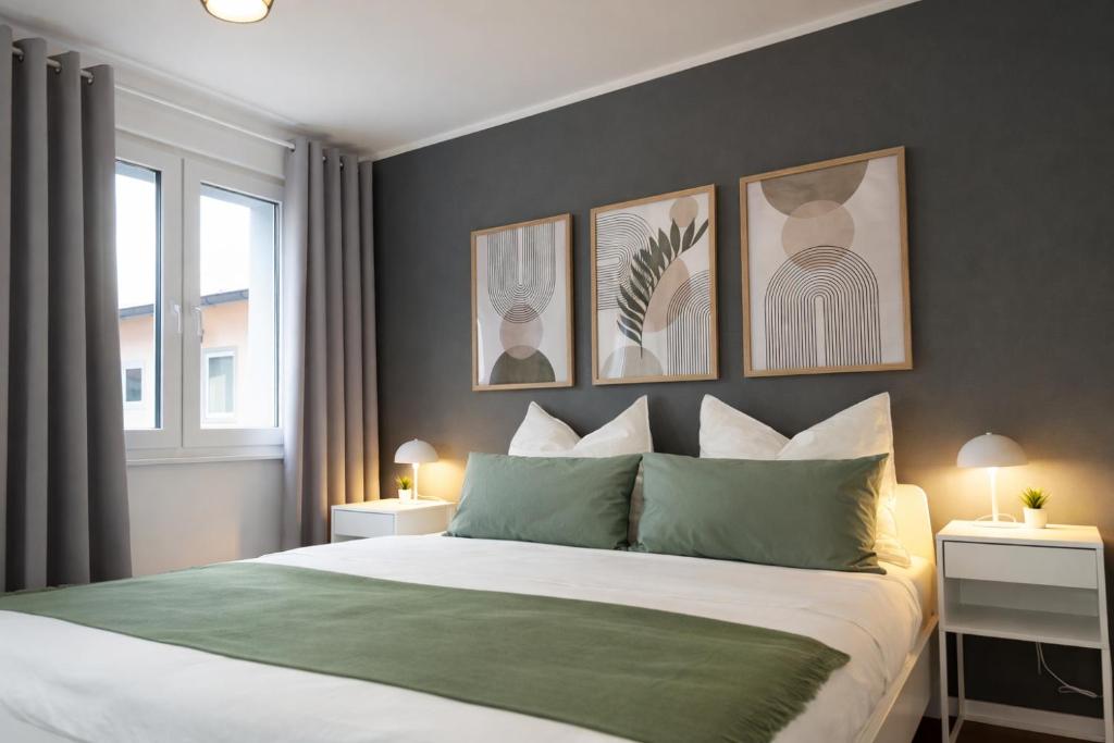 a bedroom with a bed with four pictures on the wall at Großzügiges Apartment am Limbecker Platz mit Cafés, Top Anbindung & Netflix in Essen
