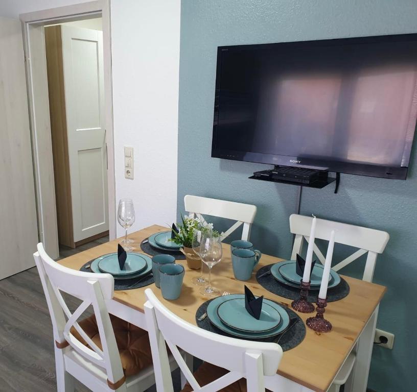 a dining room table with chairs and a television at FeWo Hess in Rust