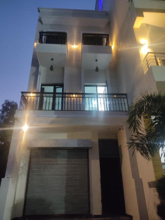 a white house with a balcony and a garage at TIP TOP PG - Paying Guest in Phagwāra