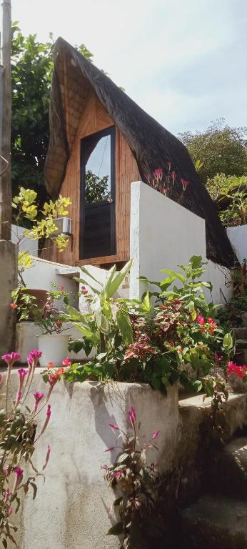 a small house with a window and some flowers at Bamboo Payag Batangas in Laurel