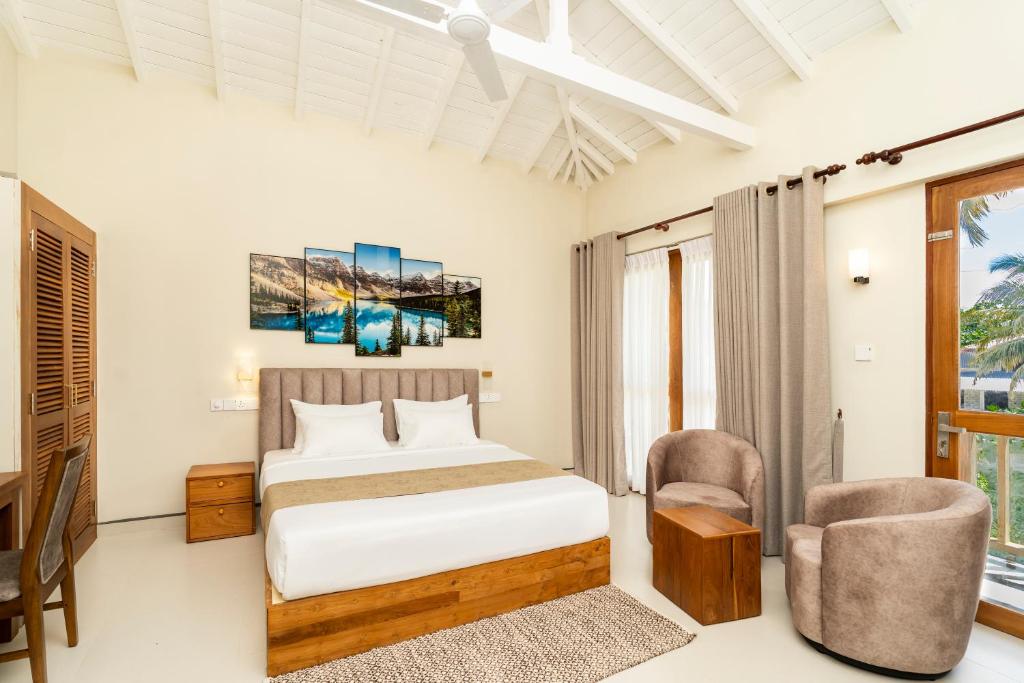 a bedroom with a bed and a desk and chair at Orchid Resort By Paradise in Habaraduwa Central