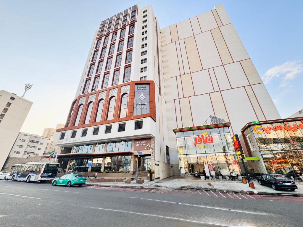 a tall building with cars parked in front of it at فندق قرى Qira Hotel in Mecca