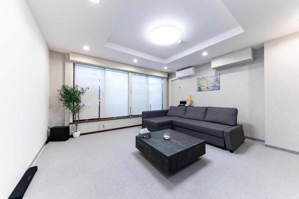 a living room with a couch and a table at Kawasaki Central House in Kawasaki