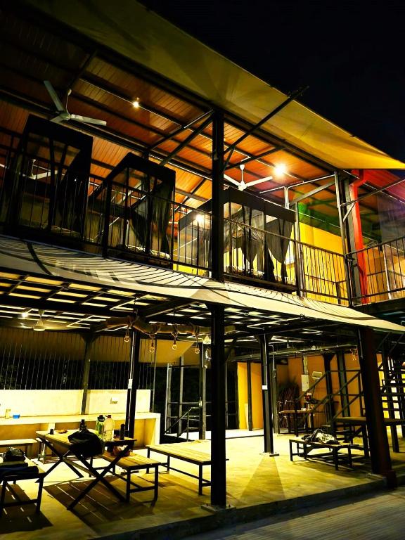 a building with benches and tables in front of it at Wildcat hostel Yala in Kataragama