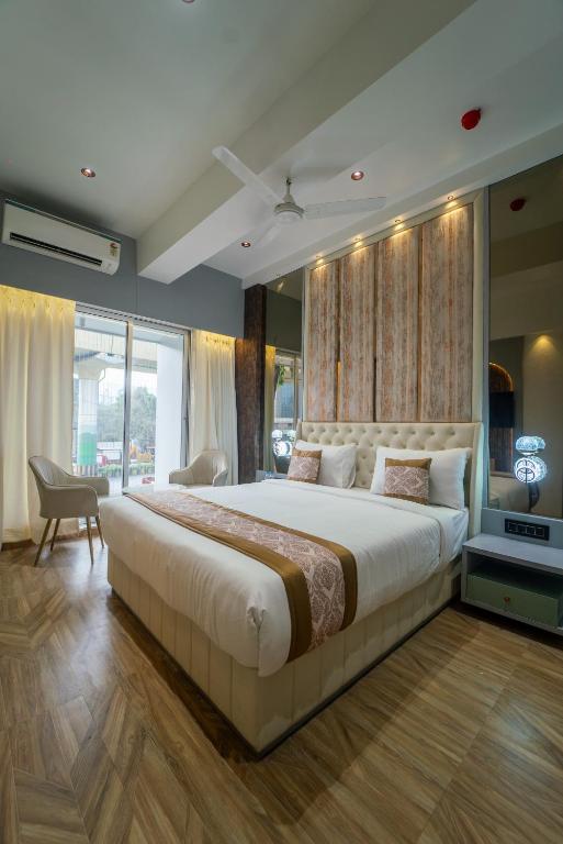 a bedroom with a large bed and a large window at Hotel Royal Inn in Thane