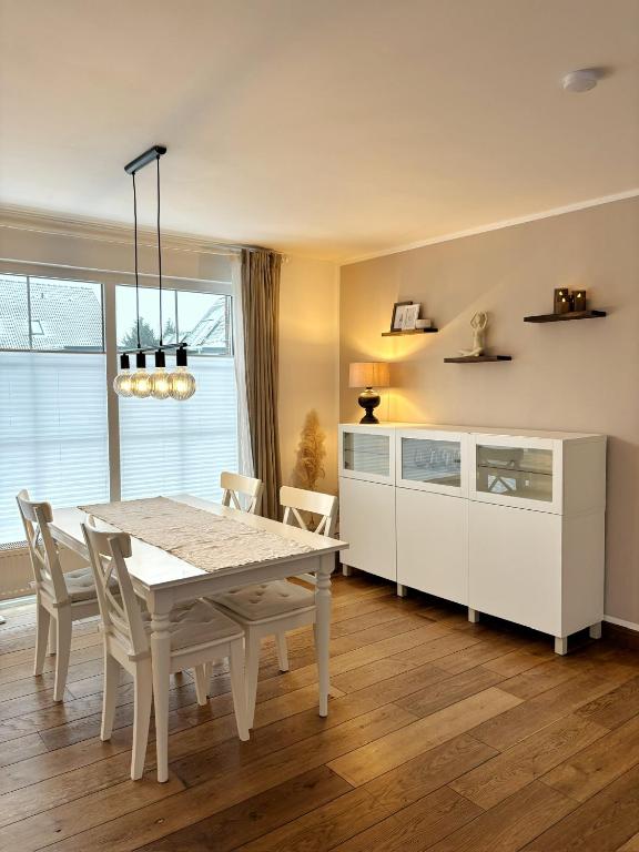 a dining room with a white table and chairs at Ferienhaus Sandstrand in Cuxhaven