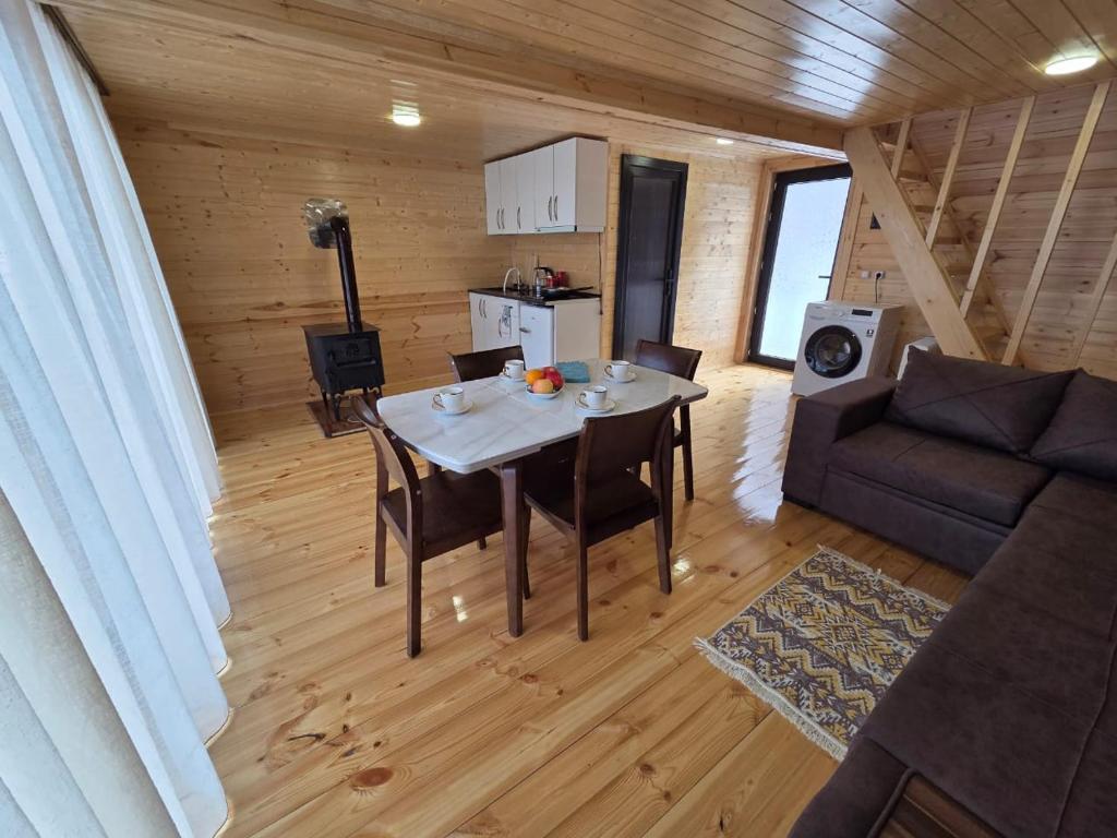 a kitchen and living room with a table and a couch at Lasha's Cottage in Mestia