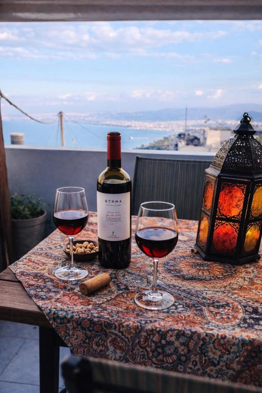 a bottle of wine and two glasses on a table at Azure Loft in Rodhiá