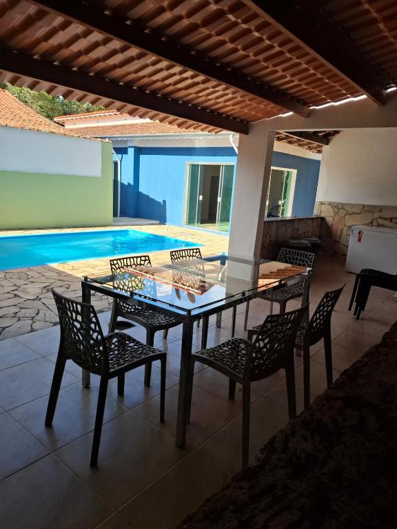a table and chairs on a patio with a swimming pool at Casazul in Lavrinhas
