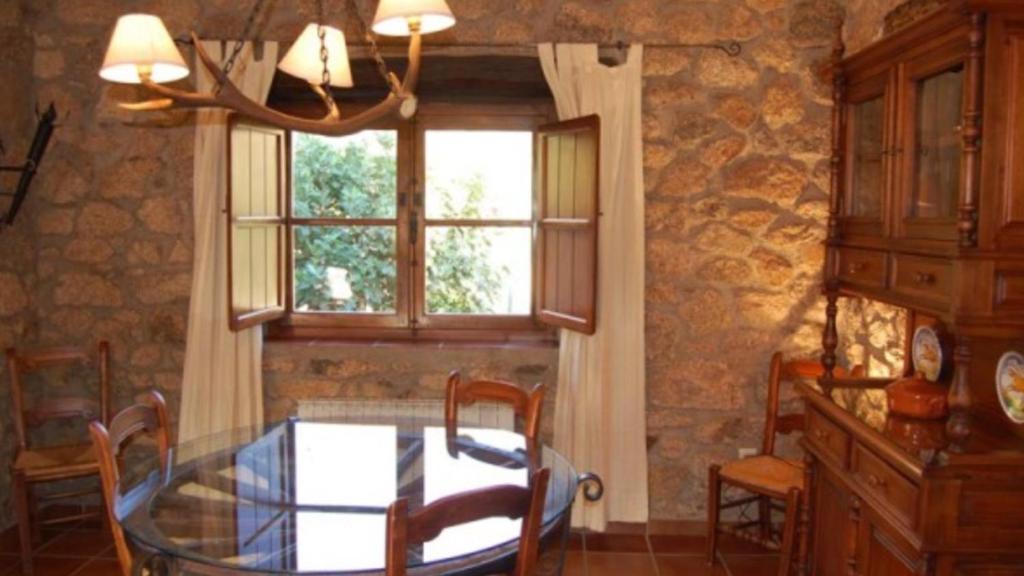 a dining room with a glass table and a window at Apartamentos en finca privada in La Borrega