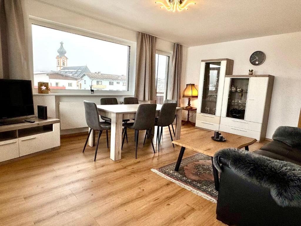 a living room with a table and chairs and a large window at Apartment Angela in Mittersill
