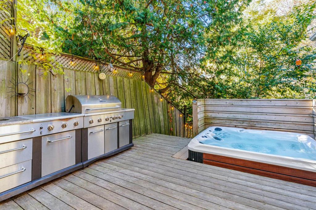 a hot tub sitting on a wooden deck next to a hot tub at Hot Tub with Backyard Play Area in Toronto