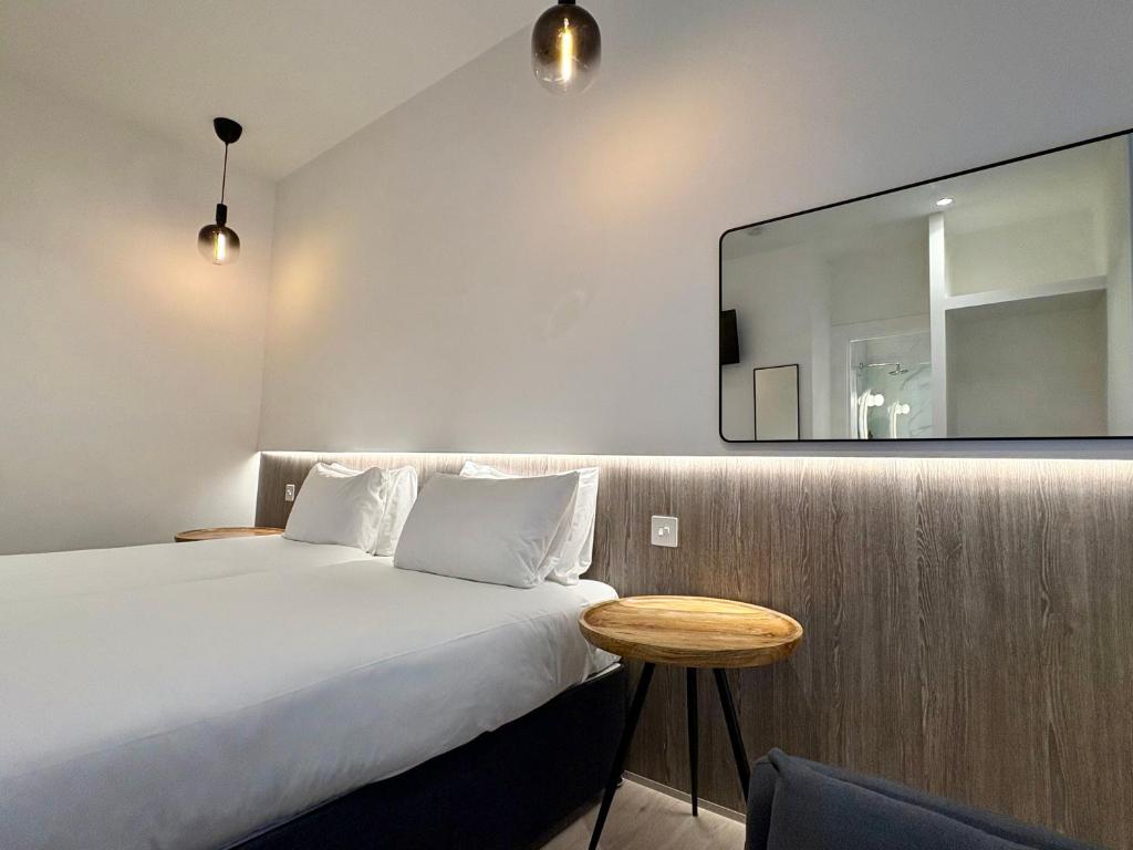 a bedroom with a bed and a mirror on the wall at RIOSHOUSE Henley in Henley on Thames