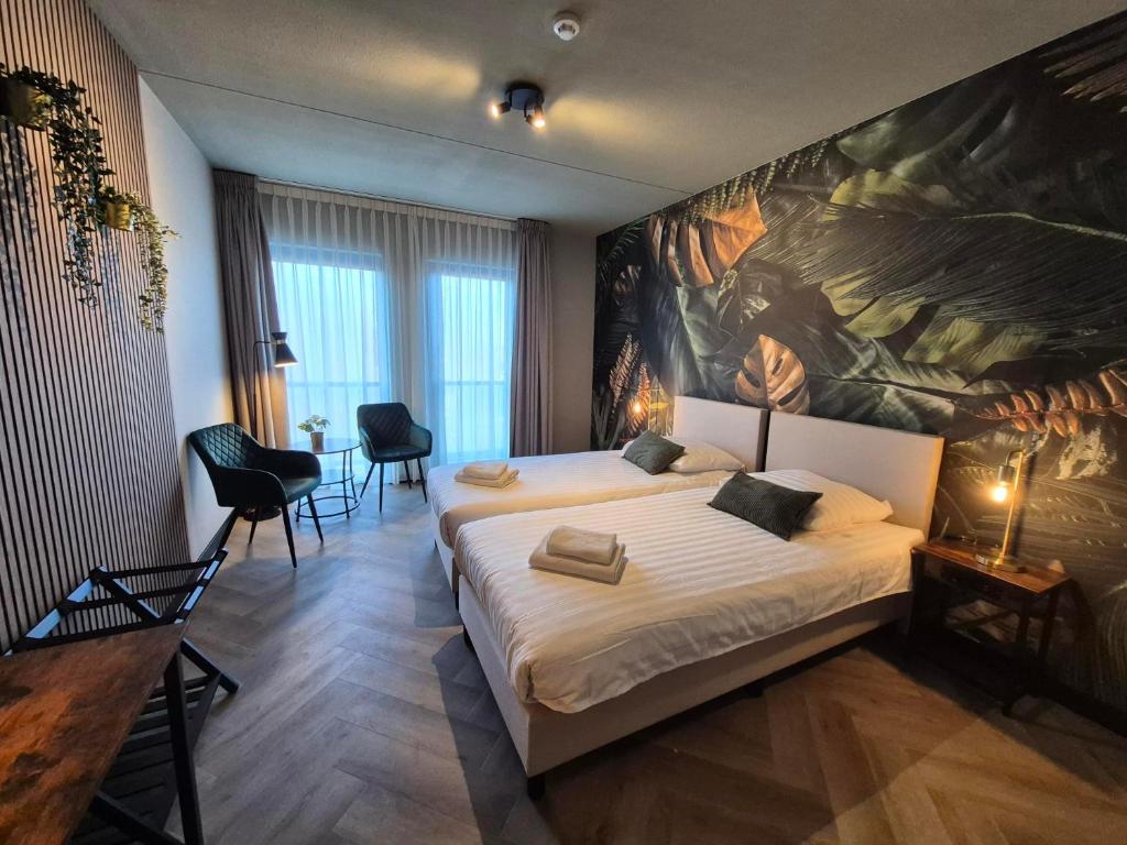 a bedroom with two beds and a large painting on the wall at Hotel Restaurant 't Trefpunt in Made