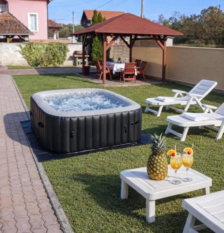 a hot tub in a yard with a table and a pineapple at Oaza Resnik in Zagreb