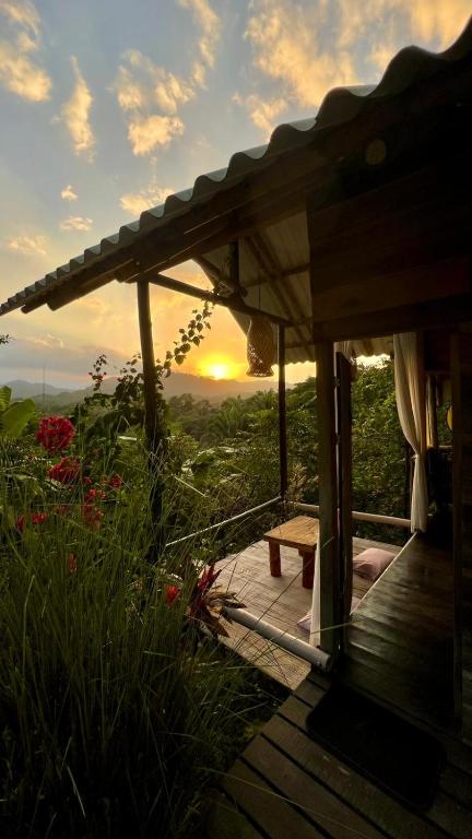 a wooden deck with a sunset in the background at Eco Cabins by La Mona Palomino in Palomino