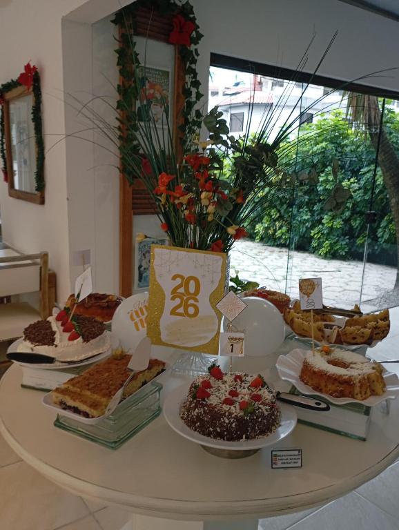 a table filled with different types of food on plates at Caravaggio Praia Hotel in Florianópolis