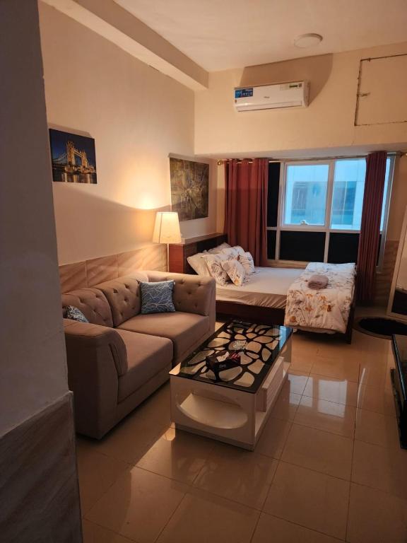 a living room with a couch and a table at Studio in Ajman in Ajman 