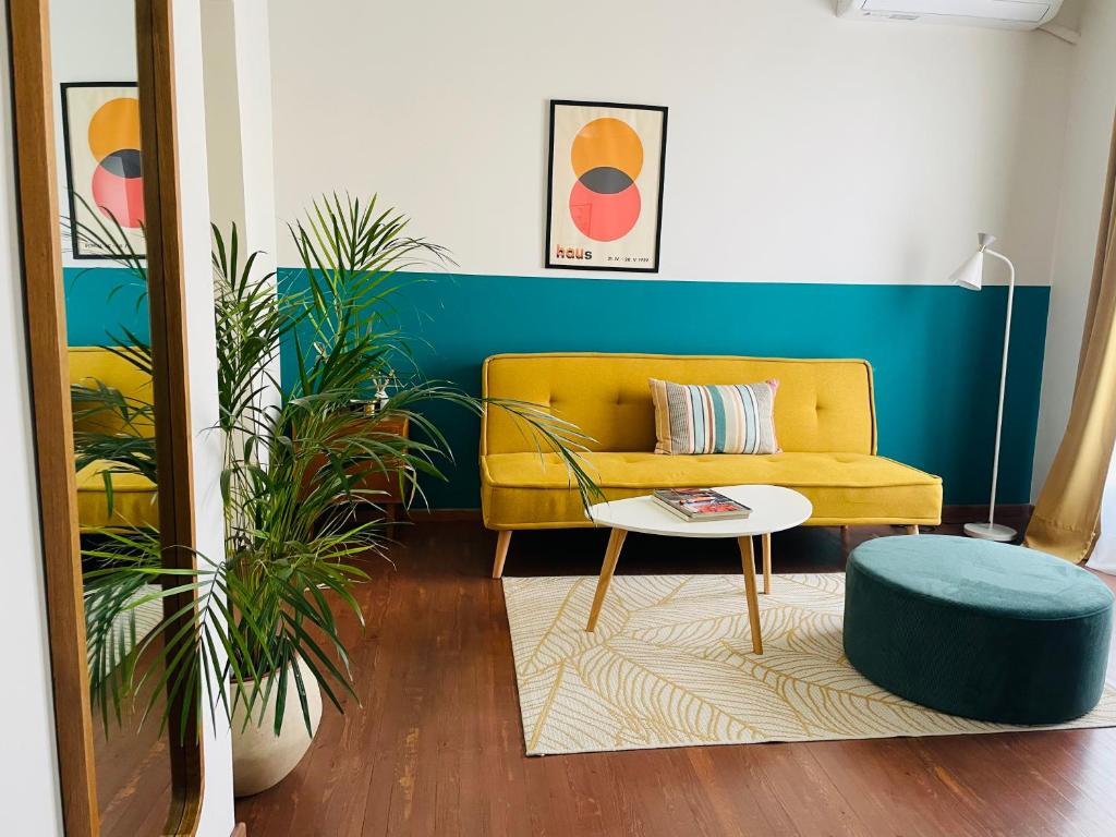 a living room with a yellow couch and a table at 19 Living in Komotini