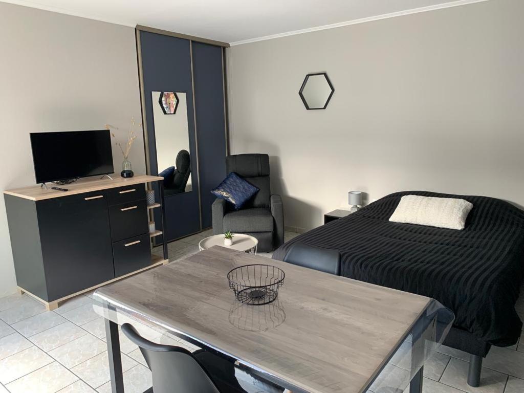 a bedroom with a bed and a table with a table sidx sidx sidx at studio meublé, résidence calme in Saint-Amand-les-Eaux