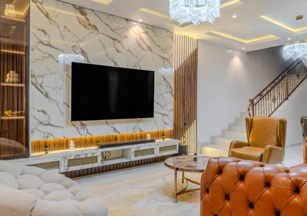 a living room with a television on a wall at Rooks Rest Inn & Apartments in Lagos