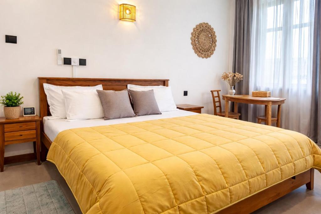 a bedroom with a large bed with a yellow blanket at Crystal Pearl Villa, Weligama - 3min to beach in Weligama