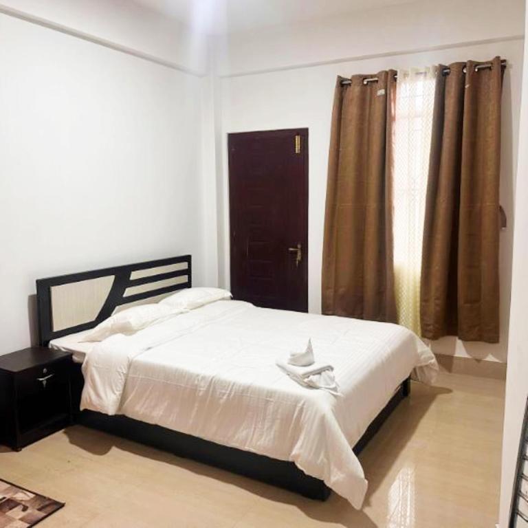 a bedroom with a bed and a window at Hotel Kiara In Shillong in Shillong