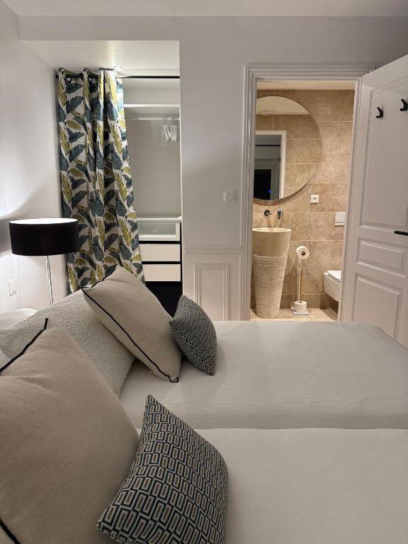 a bedroom with a white bed and a bathroom at La Maison Dehlinger, chambres hôtelières et gîte in Gros-Réderching