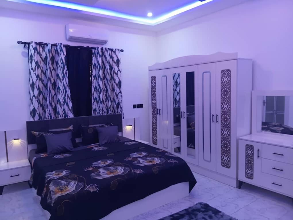 a bedroom with a large bed and a mirror at Perry Hills Apartment in Tokuse