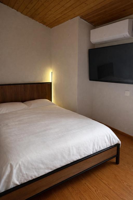 a bedroom with a bed and a flat screen tv at Kathryns apartment in Sinarádes