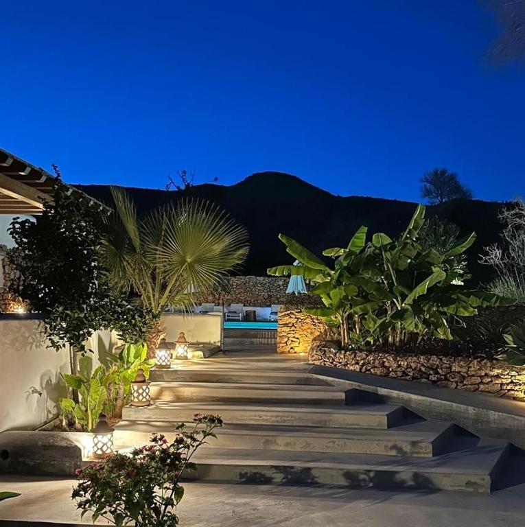 a pathway with a bench in a garden at night at Morna valley in Sant Carles de Peralta