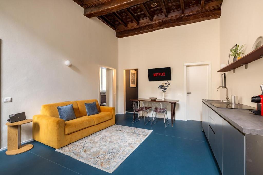 a living room with a yellow couch and a kitchen at Dal Cardinale in Novara