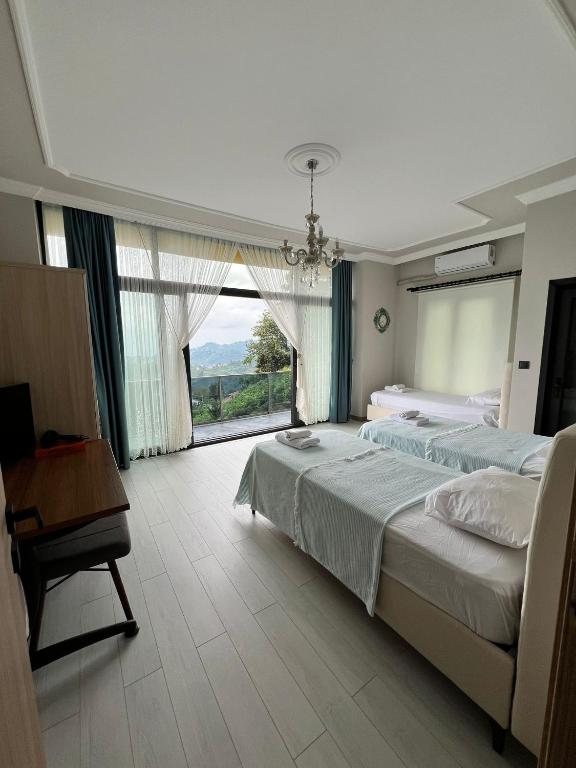 a bedroom with a large bed and a large window at Çolakoğlu konağı in Cayeli