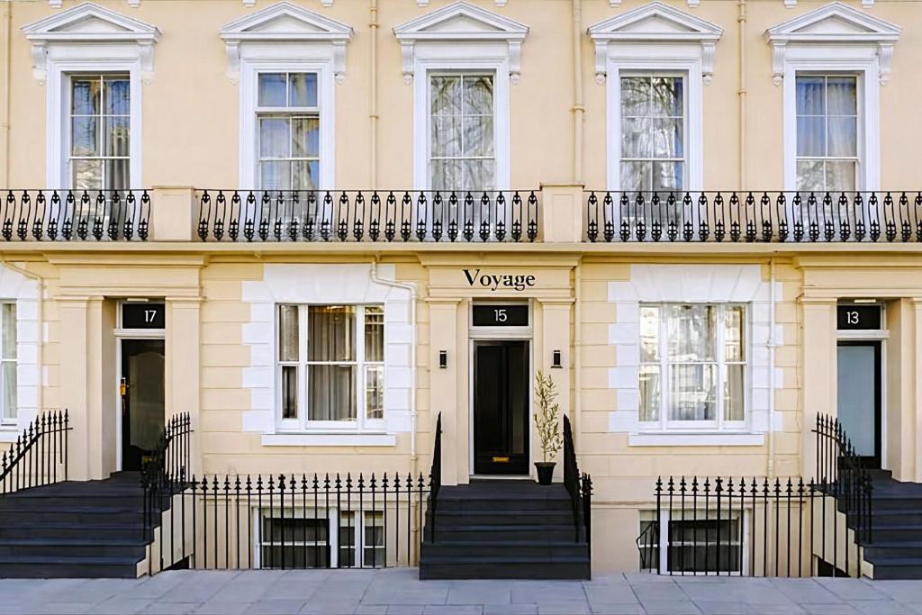 a yellow building with a balcony on top of it at The Voyage Hotel Paddington in London
