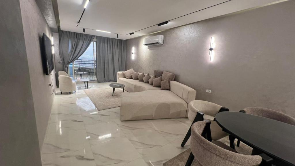a living room with a couch and a table and chairs at كورنيش نيل معادي in Al Ma‘şarah