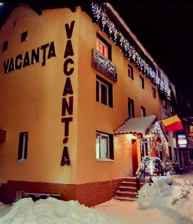 a building with a sign on the side of it at Pensiunea Vacanta in Lupeni