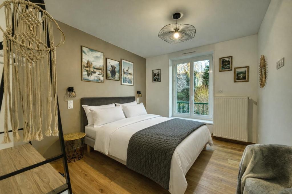 a bedroom with a bed and a chair and a window at Au Balcon de la Basilique in Boulogne-sur-Mer