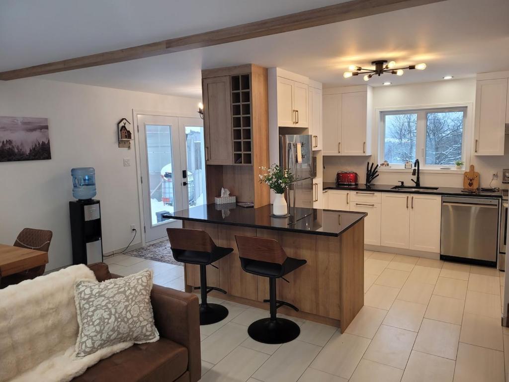 a kitchen with a island in the middle of a living room at Le Chalet du Domaine Gourmand in Thetford Mines