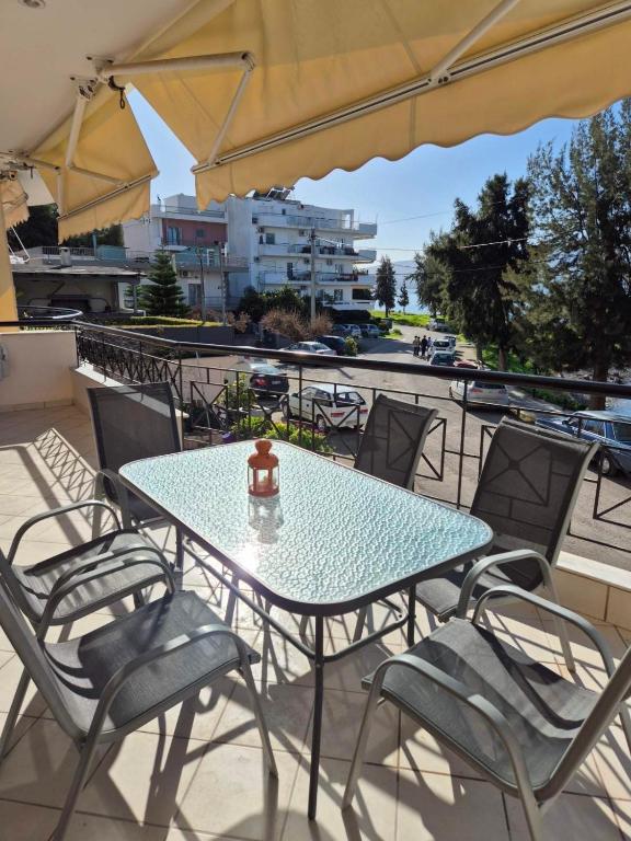 a blue table and chairs on a balcony at Sea View Artaki Apartment in Nea Artaki