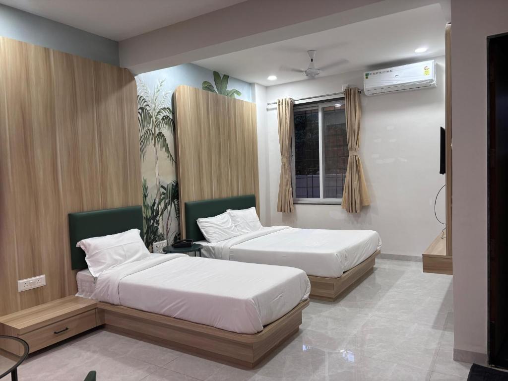 a bedroom with two beds and a television in it at Sukhawan Hotel in Kalamb