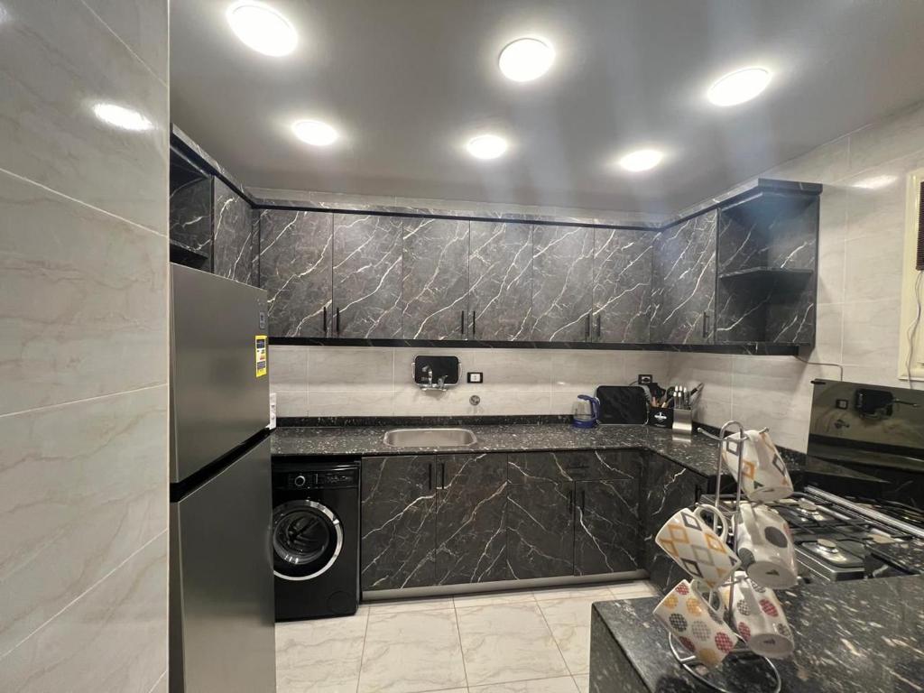 a kitchen with a washer and dryer in it at كورنيش نيل معادي in Al Ma‘şarah