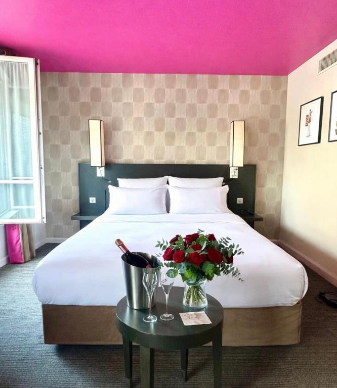 a hotel room with a bed with flowers on a table at Hôtel Aero Paris Passy in Paris